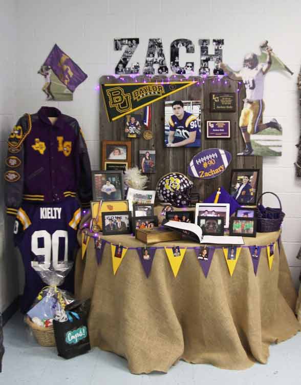 Table set up at graduation party with school colors, pictures, and guest sign-in book