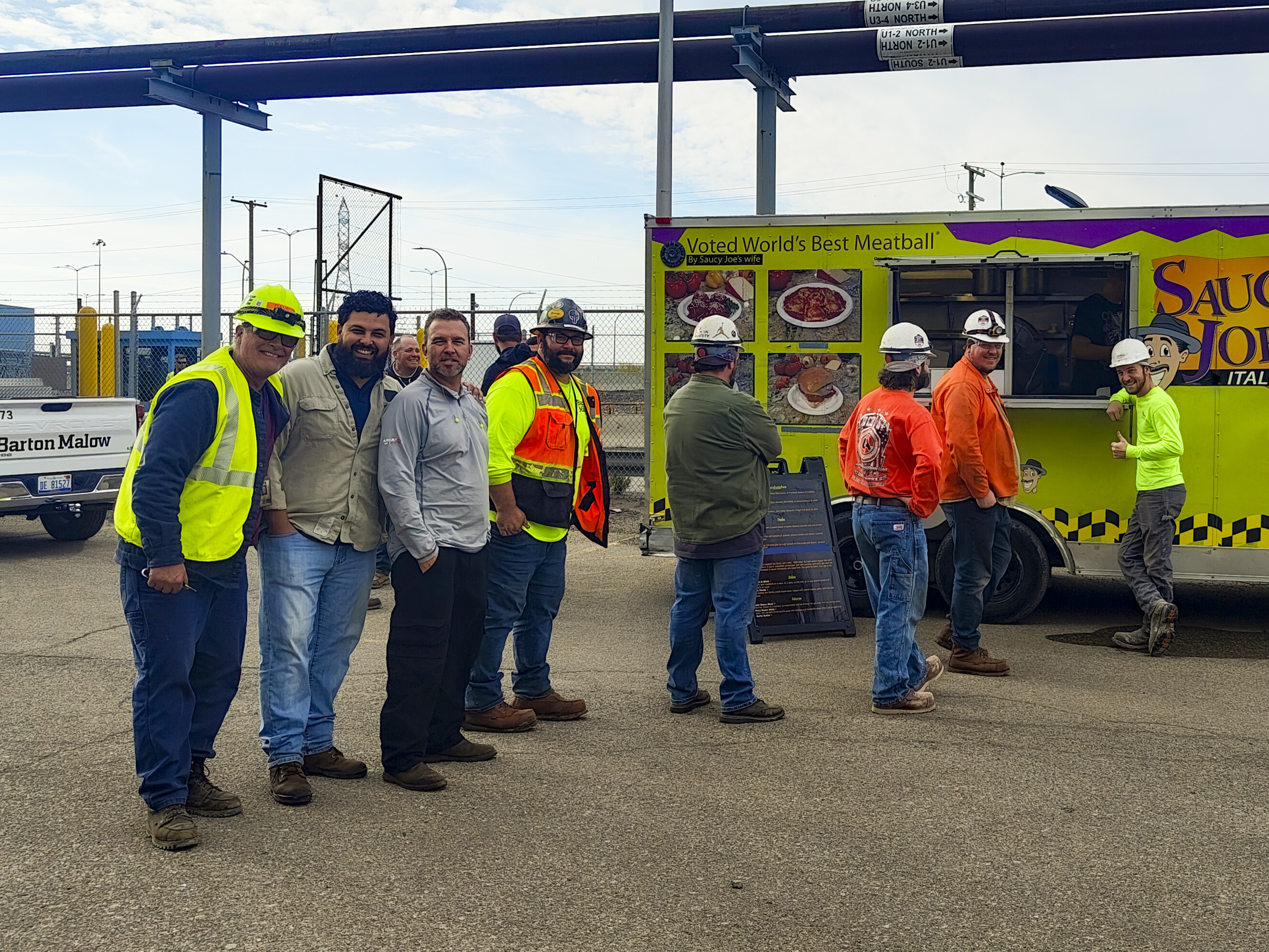 Staff Smiling in front of Saucy Joe's Food Truck