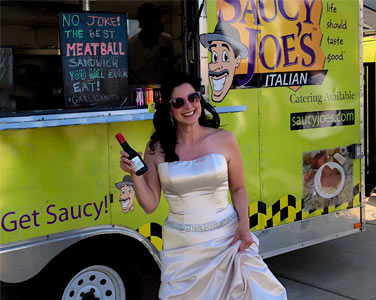 Smiling Bride with Sunglasses and Champagne in front of Saucy Joe's Food Truck